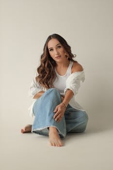 Young woman in casual attire with relaxed pose, denim jeans, and calm expression.